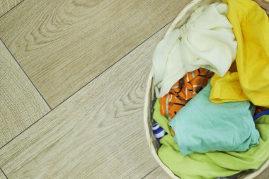 Üst Manzara Elbiseler Ahşap zeminde çamaşır sepetinde