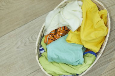 Üst Manzara Elbiseler Ahşap zeminde çamaşır sepetinde