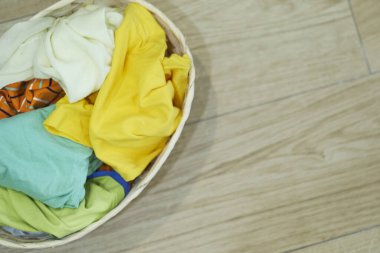 Üst Manzara Elbiseler Ahşap zeminde çamaşır sepetinde