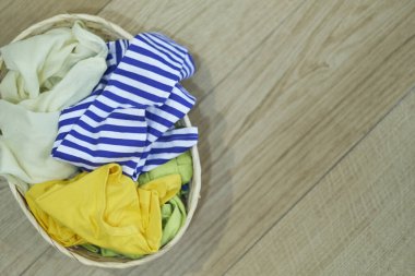 Üst Manzara Elbiseler Ahşap zeminde çamaşır sepetinde