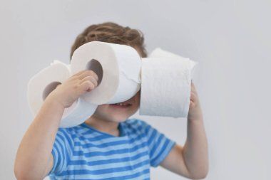 Aktif çocuk tuvalet kağıdıyla retro filtrede oynuyor, çocuk tuvalet kağıdına bakıyor, çocuk iki beyaz mendil tutuyor, çocuk sağlığı konsepti var.