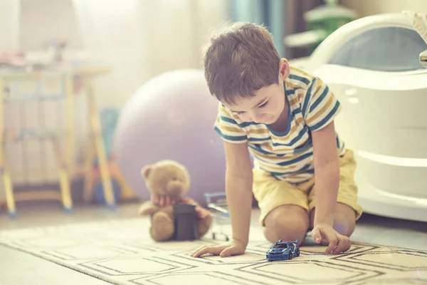 Malý chlapec hraje sám v dětském pokoji a používá kartu smart house k poslechu pohádek. — Stock fotografie