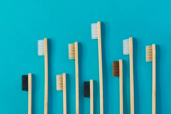 Dřevěné zubní kartáčky na modrém pozadí. koncepce nulového odpadu. Zubní péče bez platýze. — Stock fotografie
