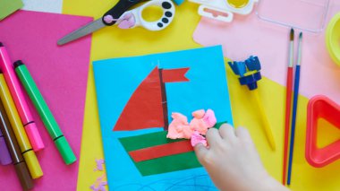 Okul malzemeleri, sarı arka planda kırtasiye malzemesi - manşet için yer. Çocuk kalemle çizmeye ve renkli kağıt uygulamaya hazır. Üst görünüm.