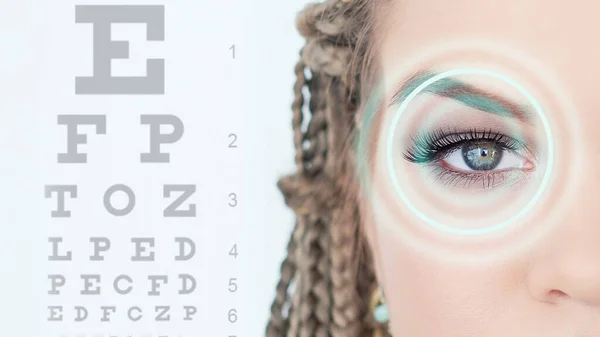 시력 검사, 진단, 질병, 임상 치료의 개념. 의학, 시력 관리, 레이저 교정, 사람들. 파란 배경을 눈표로 가리키는 아름다운 젊은 여자 — 스톡 사진