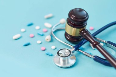 Kahverengi tokmak ve mavi arka planda tıbbi steteskop. Beceriksizlik ve tıbbi hata için sembol fotoğrafı