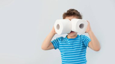 Aktif çocuk tuvalet kağıdıyla retro filtrede oynuyor, çocuk tuvalet kağıdına bakıyor, çocuk iki beyaz peçete tutuyor, tuvalet kağıdına dürbün gibi bakıyor.