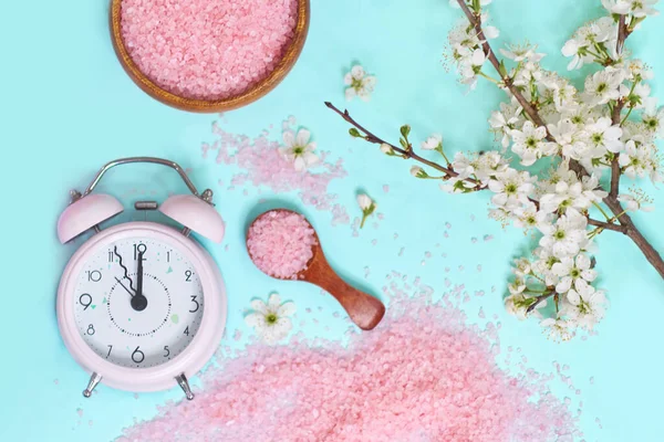 Spa setting spring flowers with towel ,salt in bowl, Spring Time Change, Spring flowers and Alarm Clock.