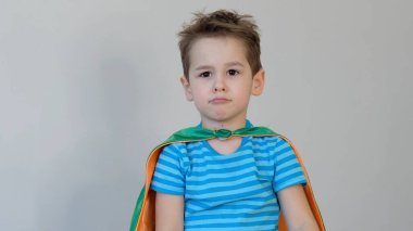 Üzgün çocuk süper kahraman. Küçük çocuk süper kahramanı oynuyor. Süper kahraman kostümü giymiş bir çocuk. çocuk yeşil maskesi, doğa bakımı konsepti