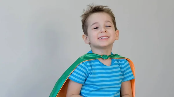 Ritratto di un ragazzo sorridente. Un ragazzino che fa il supereroe. Ragazzo in costume da supereroe. bambino felice. maschera verde, concetto di cura della natura — Foto Stock