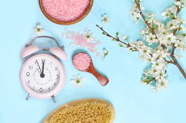 Spa setting spring flowers with towel ,salt in bowl, Spring Time Change, Spring flowers and Alarm Clock.