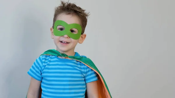 Un niño jugando a ser un superhéroe. Niño con un disfraz de superhéroes. niño feliz. máscara verde, concepto de cuidado de la naturaleza — Foto de Stock