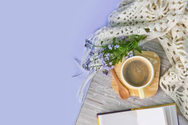 Samimi ev hayatı: bir fincan sıcak kahve, bahar çiçekleri ve sıcak ekoseyle açılan kitap. İlkbahar konsepti, bedava fotokopi alanı. Üst görünümü kapat