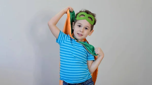 Um rapazinho a fazer de super-herói. Um miúdo disfarçado de Superheros. criança feliz. máscara verde, conceito de cuidados da natureza — Fotografia de Stock