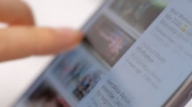 MOSCOW, RUSSIA, 7 Mart 2020: Akıllı telefondan YouTube kanallarını kaydıran kız. YouTube, merkezi San Bruno, Kaliforniya 'da bulunan bir Amerikan video paylaşım sitesidir..