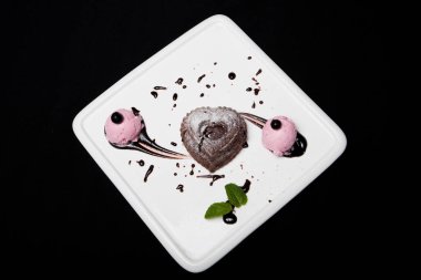 Tatlı fondan çikolata siyah bir zemin üzerine beyaz bir plaka üzerinde dondurma ile. Enfes Fransız çikolata tatlı fondan