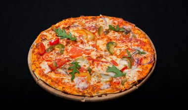 Pizza bir ahşap tahta üzerinde siyah bir arka plan üzerinde