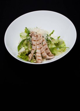 Beyaz tabak RIM siyah tablo üzerinde balsamik soslu lezzetli taze Sezar salata tavuk ve sebze yakın çekim dekore