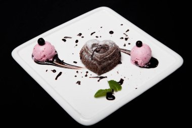 Tatlı fondan çikolata siyah bir zemin üzerine beyaz bir plaka üzerinde dondurma ile. Enfes Fransız çikolata tatlı fondan