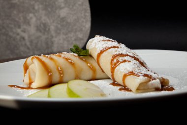 Siyah bir zemin üzerine elma krep. Restoran Menü