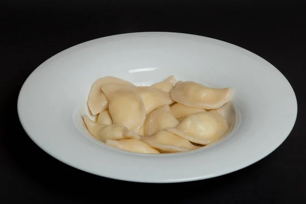 Spenat Dumplings i en vit platta på svart bakgrund — Stockfoto