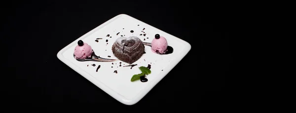 Dessert fondan chocolade met ijs op een witte plaat op een zwarte achtergrond. Prachtige Franse chocoladedessert fondan, plaats voor tekst — Stockfoto