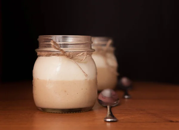 Sobremesa deliciosa em um frasco de vidro em um fundo preto — Fotografia de Stock