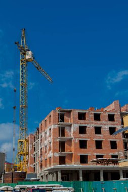 Şantiye binasının bir yeni daire yüksek kule ile mavi gökyüzü karşı vinç. Yerleşim alanı geliştirme. Gayrimenkul Proje büyüme kavramı