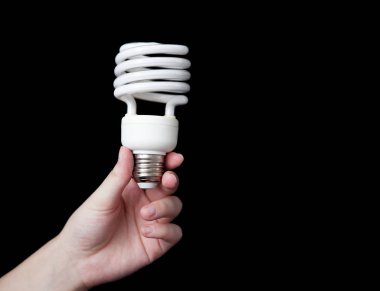 Bir ampul siyah arka plan ile elini tutuyor