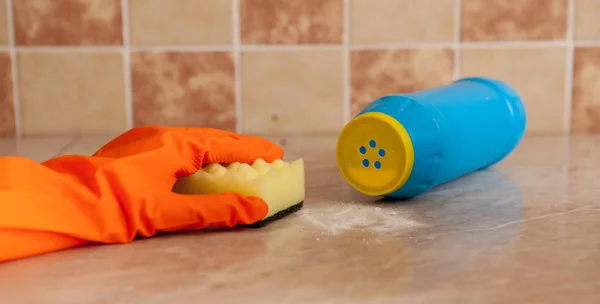 Mano en guantes de goma de orenge lavar la superficie de la con una esponja amarilla suave cerca del detergente rayado —  Fotos de Stock