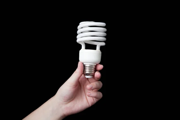Hand is holding a light bulb with black background — Stock Photo, Image