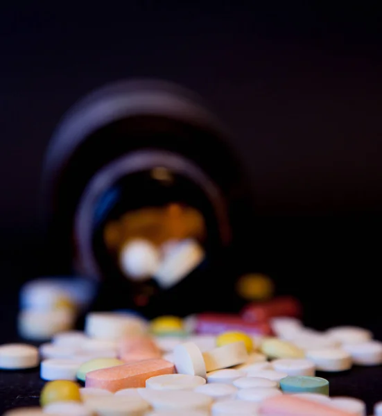 A bottle of spilled pills on black background.Levitating tablets. Tablets on a dark background that are falling. Tablets. Medicine is healthy. Close capsules. Tablets are falling on a black background — Stock Photo, Image