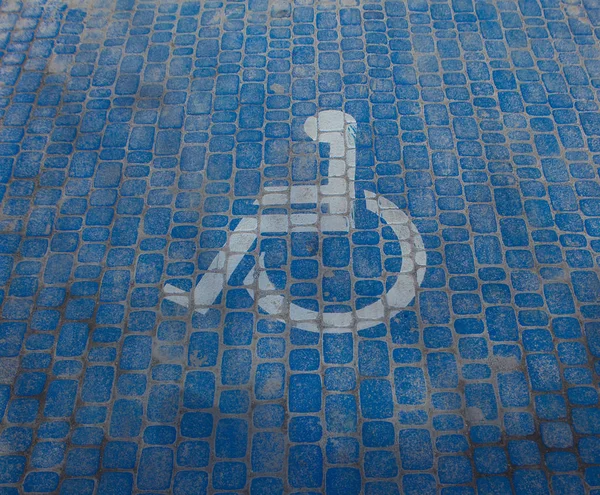 Vista superior no sinal de estacionamento para pessoas incapacitadas. Espaço de estacionamento desativado e símbolos de cadeira de rodas no pavimento — Fotografia de Stock