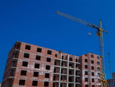Şantiye binasının bir yeni daire yüksek kule ile mavi gökyüzü karşı vinç. Yerleşim alanı geliştirme. Gayrimenkul Proje büyüme kavramı