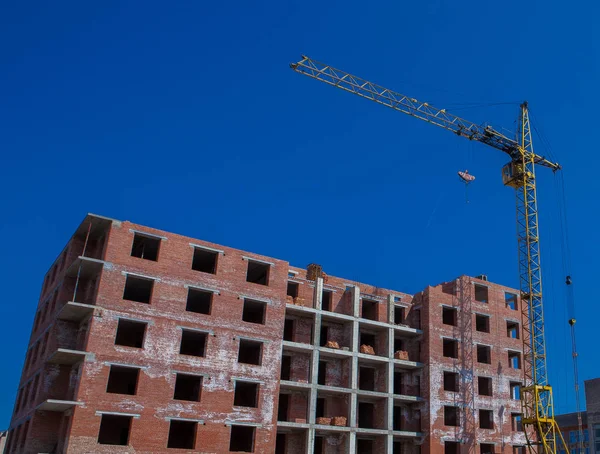 Baustelle eines neuen Mehrfamilienhauses mit Turmdrehkränen vor blauem Himmel. Wohngebietsentwicklung. Wachstumskonzept für Immobilienprojekt — Stockfoto
