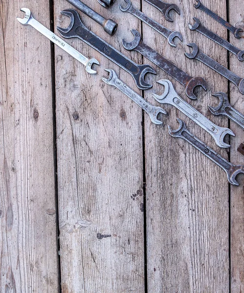 Llave de metal herramientas oxidadas que yacen sobre una mesa de madera negra. Martillo, cincel, sierra, llave de metal. Espacio de copia — Foto de Stock