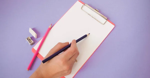 A nő kezében ceruza és notebook a lila háttér, üzleti vagy tanulmányi fogalom Flatlay — Stock Fotó
