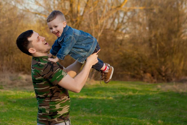 Glücklicher junger Vater, der mit seinem Sohn im Freien spielt. Familienkonzept. Kopierraum — Stockfoto