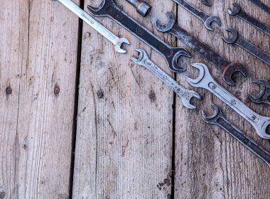 Siyah ahşap masanın üzerinde yatan metal anahtarı paslı araçları. Çekiç, keski, demir testeresi, metal anahtarı. Kopya alanı.