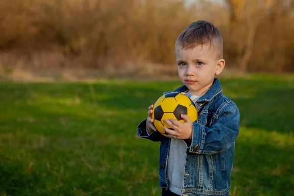 Zweijähriger Junge hält Fußballball im Park — Stockfoto