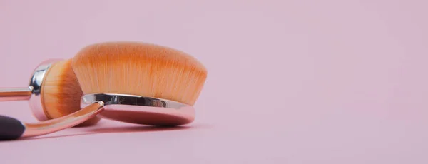 Set med ovala borstar för makeup på rosa bakgrund — Stockfoto