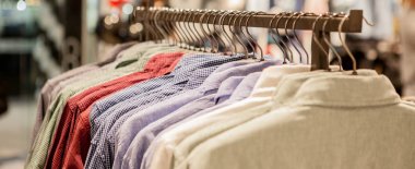 Giyim bir rafta asılı. Askıları ile gömlek. Erkekler şık giysiler. Vitrin, satışı, alışveriş. Moda ve alışveriş kavramı