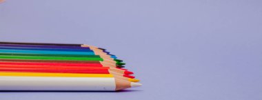 Menekşe arka plan üzerinde renkli kalemler projeleri ve duyurular için