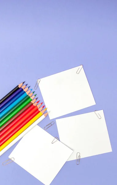 Leere Papierbögen und Farbstifte auf violettem Hintergrund für Projekte und Ankündigungen — Stockfoto