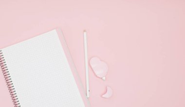 Defter, beyaz çarşaf, kalem, düzeltmen. Pembe bir arka plan. Instagram kavramı