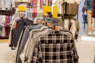 Giyim bir rafta asılı. Bez askıları gömlek ile. Erkekler şık giysiler. Moda ve ticaret kavramı