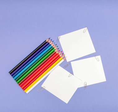 Kağıtları ve renkli kalemler Menekşe arka plan üzerinde yaprak projeleri ve Duyurular, kopya alanı için boşluklar