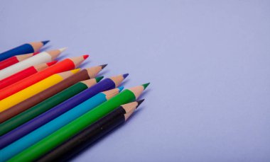 Menekşe arka plan üzerinde renkli kalemler projeleri ve duyurular için