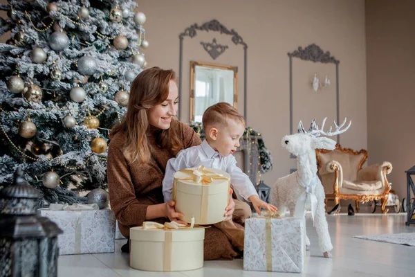 Bonito feliz menino no santa chapéu desembrulhar natal presente caixa no holi — Fotografia de Stock