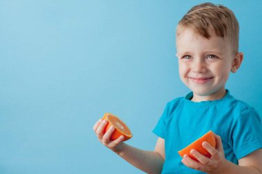 Little Boy mavi arka plan, di elinde bir Portakal Holding